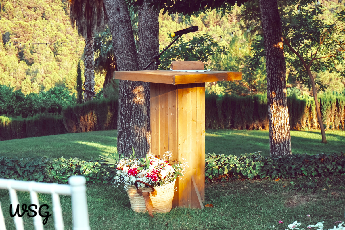 Wedding speech podium in a beautiful outdoor garden setting with floral decoration, perfect for a heartfelt wedding speech template.