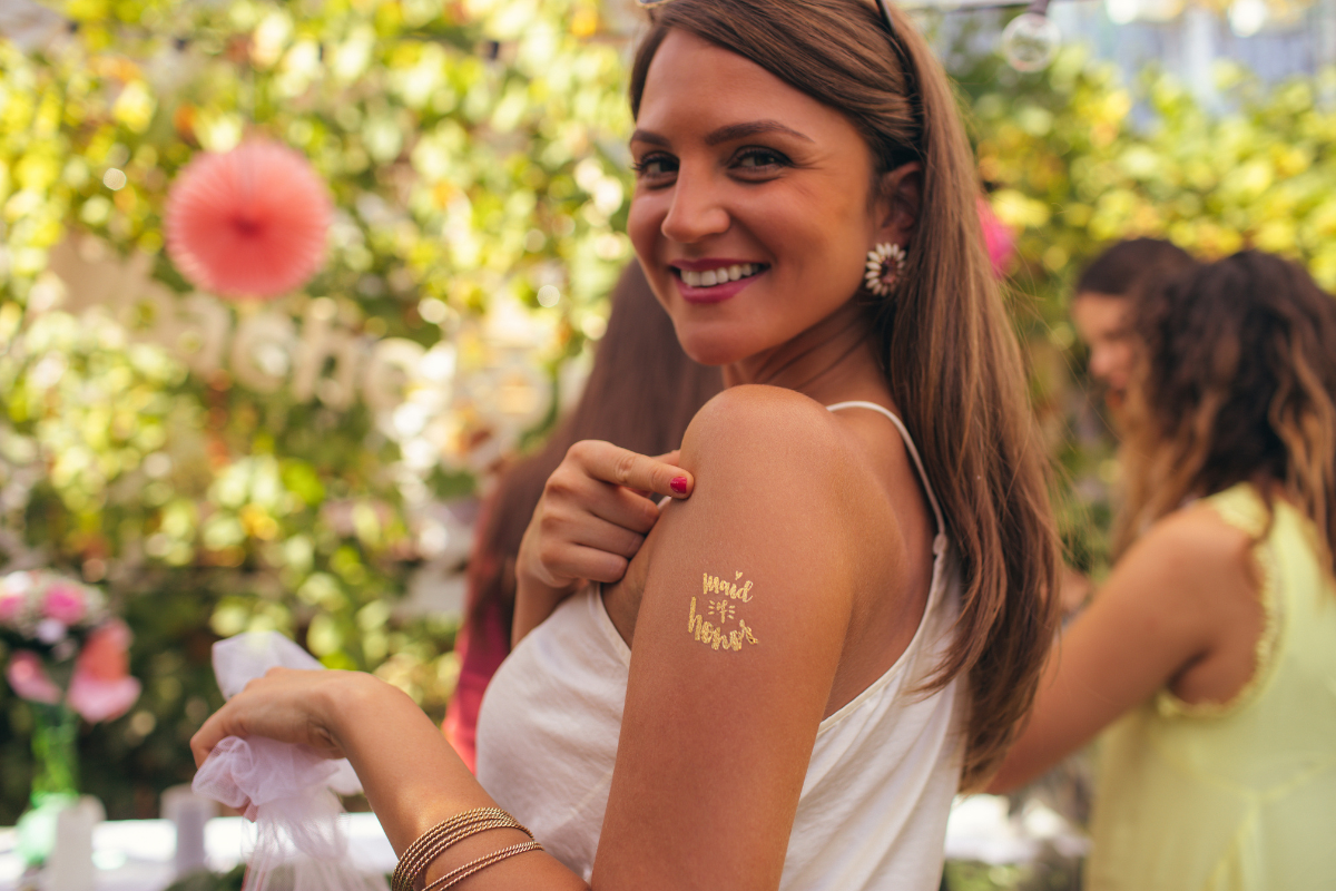 a pretty girl pointing at her maid of honor tag at wedding setting.