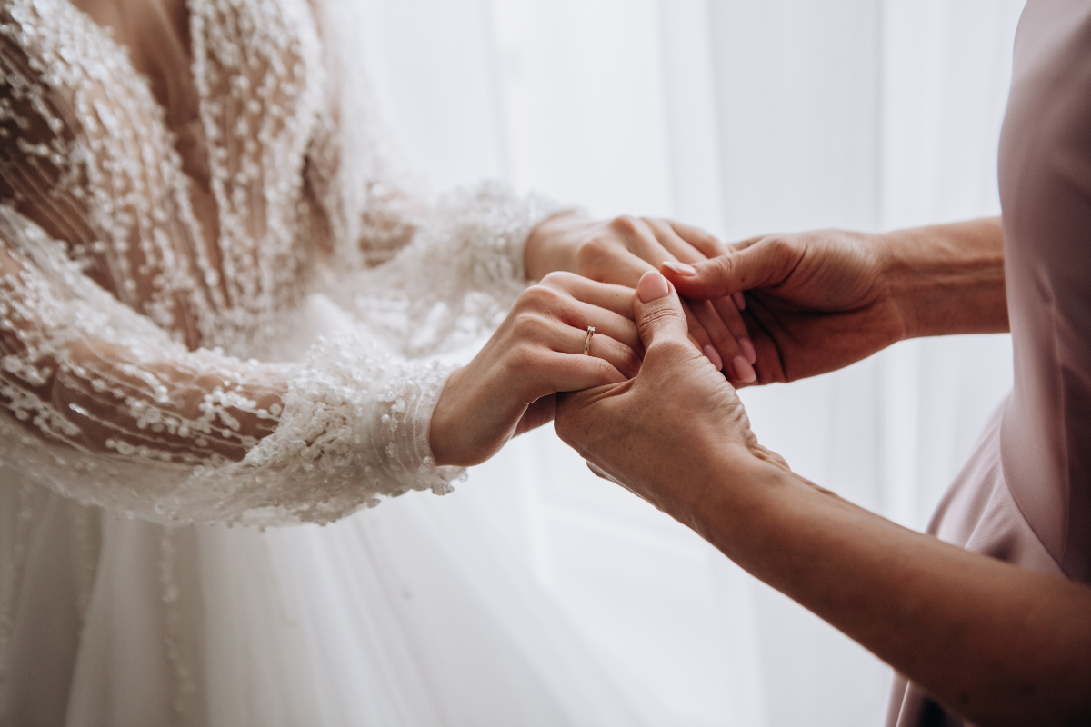 close up image of a mother holding her daughter's hand in her wedding,