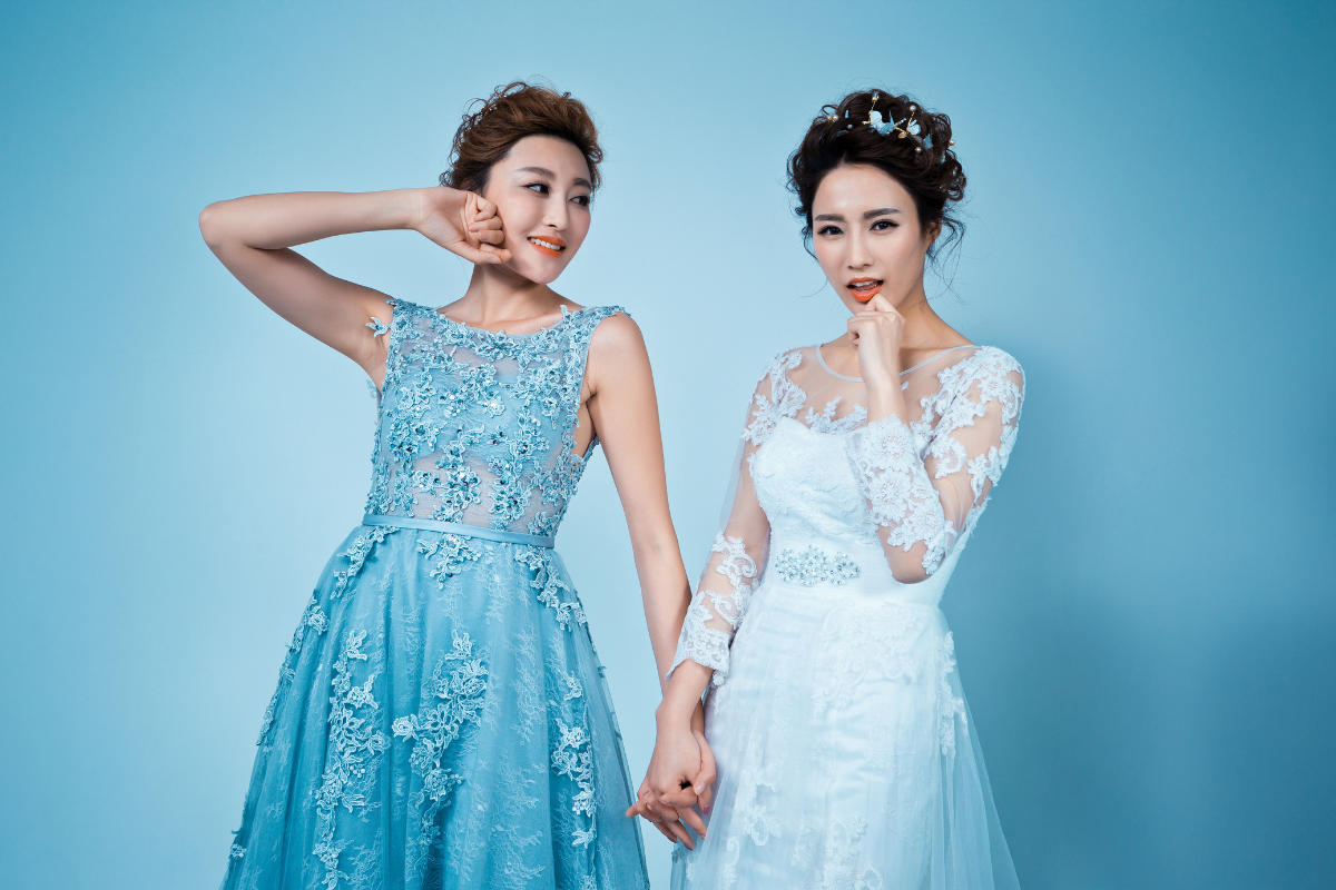 matron of honor and her best friend, the bride, holding hands and smiling.