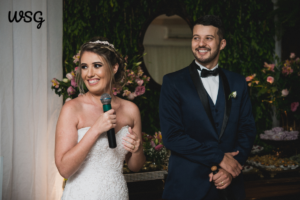 Bride giving a speech in the correct wedding speech order with groom by her side